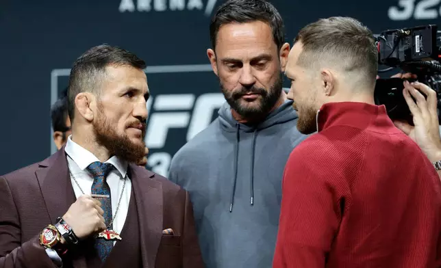 UFC bantamweight champion Merab Dvalishvili, left, of Georgia, faces off with challenger Petr Yan, of Russia, as UFC matchmaker Mick Maynard looks on during a news conference promoting UFC 323, Thursday, Dec. 4, 2025, in Las Vegas. (Steve Marcus/Las Vegas Sun via AP)