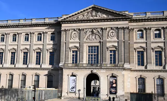 FILE- People walk by an entrance of the Louvre museum, Thursday, Oct. 30, 2025 in Paris. (AP Photo/Emma Da Silva, file)