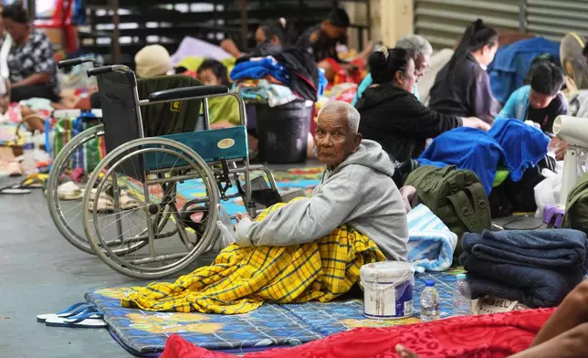 Thai residents who fled homes following the clashes between Thai and Cambodian soldiers, rest at an evacuation center in Surin province, Thailand, Wednesday, Dec. 10, 2025. (AP Photo/Sakchai Lalit)