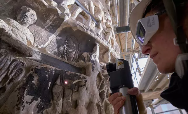 Restorer Mariangela Santella uses a short-pulse laser to selectively remove encrustations from the surface of a bas-relief on the second-century A.D. Column of Marcus Aurelius in central Rome, Thursday, Dec. 18, 2025. (AP Photo/Domenico Stinellis)
