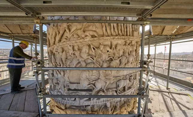 Luca Del Fra, press officer for Rome's Special Superintendency looks at bas-reliefs depicting scenes from a battle on the second-century A.D. Column of Marcus Aurelius in central Rome during a media tour, Thursday, Dec. 18, 2025. (AP Photo/Domenico Stinellis)