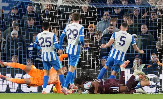 Aston Villa's Ollie Watkins, on the ground, scores their side's first goal of the game during the English Premier League soccer match between Brighton and Hove Albion and Aston Villa in Brighton and Hove, England, Wednesday Dec. 3, 2025. (Gareth Fuller/PA via AP)