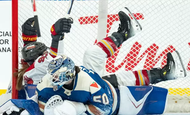 Ottawa Charge's Anna Shokhina (97) celebrates her goal as she trips over Vancouver Goldeneyes goaltender Kristen Campbell (50) during the third period of a PWHL hockey game in Vancouver, British Columbia, Tuesday, Dec. 16, 2025. (Ethan Cairns/The Canadian Press via AP)