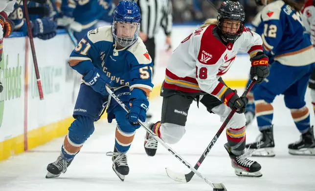Vancouver Goldeneyes' Anna Segedi (51) and Ottawa Charge's Mannon McMahon (18) vie for the puck during the third period of a PWHL hockey game in Vancouver, British Columbia, Tuesday, Dec. 16, 2025. (Ethan Cairns/The Canadian Press via AP)