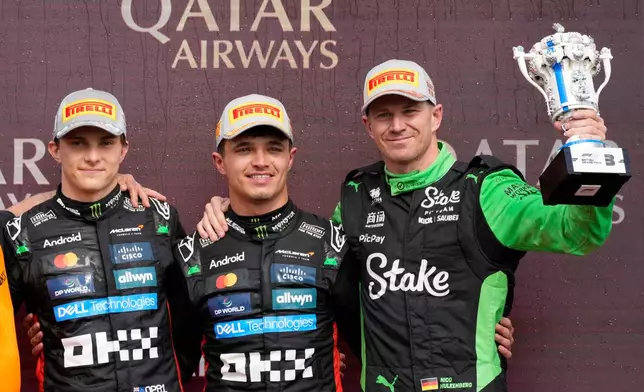 FILE-McLaren driver Lando Norris of Britain, centre, is flanked by his teammate Oscar Piastri of Australia, left, and Kick Sauber driver Nico Hulkenberg of Germany, right, as they celebrates after winning the British Formula One Grand Prix race at the Silverstone racetrack in Silverstone, England, Sunday, July 6, 2025. (AP Photo/Darko Bandic, File)