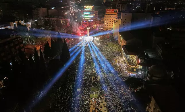 FILE - Fireworks and light beams illuminate the sky as people fill Clock Square in central Homs, western Syria, Monday, Dec. 8, 2025, to mark the first anniversary of the ousting of the Bashar Assad regime. (AP Photo/Omar Albam, File)