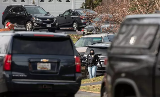 An FBI agent stands near the house where the FBI made an arrest, in Woodbridge, Va., Thursday, Dec. 4, 2025, in a nearly five-year old investigation into who placed pipe bombs in Washington before the Jan. 6, 2021 riot at the US Capitol. (AP Photo/Cliff Owen)