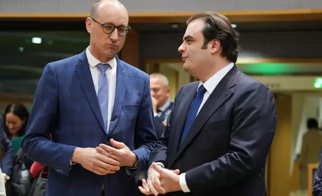 Belgium's Finance Minister Vincent Van Peteghem, left, speaks with Greece's Finance Minister Kyriakos Pierrakakis during a meeting of eurozone finance ministers at the EU Council building in Brussels, Thursday, Dec. 11, 2025. (AP Photo/Virginia Mayo)