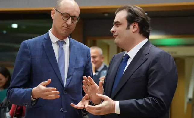Belgium's Finance Minister Vincent Van Peteghem, left, speaks with Greece's Finance Minister Kyriakos Pierrakakis during a meeting of eurozone finance ministers at the EU Council building in Brussels, Thursday, Dec. 11, 2025. (AP Photo/Virginia Mayo)