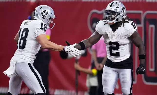 Las Vegas Raiders running back Ashton Jeanty (2) is congratulated by wide receiver Jack Bech (18) after scoring against the Houston Texans during the second half of an NFL football game, Sunday, Dec. 21, 2025, in Houston. (AP Photo/Ashley Landis)