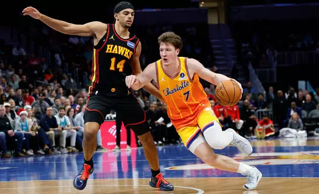 Charlotte Hornets guard Kon Knueppel (7) drives to the basket against Atlanta Hawks forward Asa Newell (14) during the first half of an NBA basketball game in Charlotte, N.C., Thursday, Dec. 18, 2025. (AP Photo/Nell Redmond)