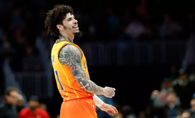 Charlotte Hornets guard LaMelo Ball smiles after making a three-point basket against the Atlanta Hawks during the first half of an NBA basketball game in Charlotte, N.C., Thursday, Dec. 18, 2025. (AP Photo/Nell Redmond)