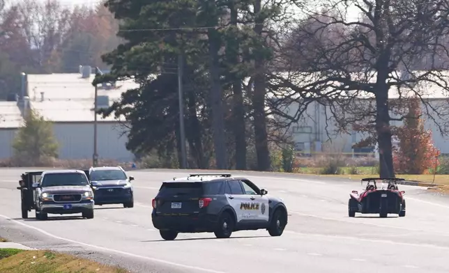 A Springdale, Ark., police vehicle, center, pulls over a convertible vehicle, right, Nov. 18, 2025, in Springdale, Ark. (AP Photo/Julio Cortez)