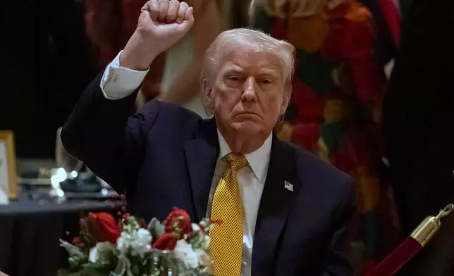 President Donald Trump pumps his fist at Christmas Eve dinner at his Mar-a-Lago club, Wednesday, Dec. 24, 2025, in Palm Beach, Fla. (AP Photo/Alex Brandon)