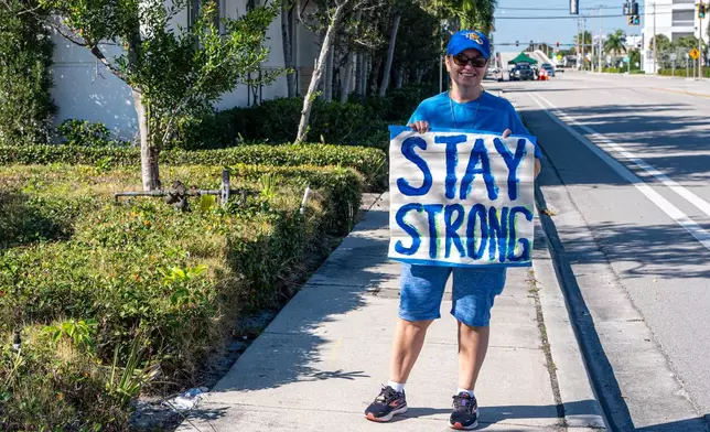 Karen Blake of Ft. Lauderdale, poses with a sign at the "Rally in Support of Ukraine" organized by the Ukrainian Association of Florida as Ukrainian President Volodymyr Zelenskyy meets with U.S. President Donald Trump at Mar-a-Lago in West Palm Beach, Fla., Sunday, Dec. 28, 2025. (AP Photo/Jen Golbeck)