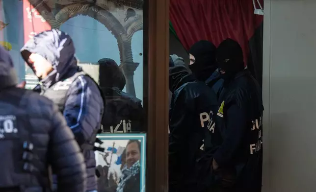 Police officers inspect a charitable association supporting Palestinian civilians in Milan, Italy, Saturday, Dec. 27, 2025 after Italian investigators have arrested nine people suspected of raising millions of euros for Hamas. (Claudio Furlan/LaPresse via AP)
