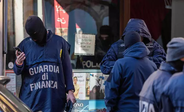 Police officers inspect a charitable association supporting Palestinian civilians in Milan, Italy, Saturday, Dec. 27, 2025 after Italian investigators have arrested nine people suspected of raising millions of euros for Hamas. (Claudio Furlan/LaPresse via AP)