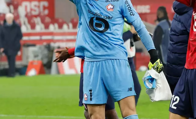 Lille's goalkeeper Berke Ozer celebrates with teammates after the French League One soccer match between Lille and Marseille in Villeneuve-d'Ascq, outside Lille, France, Friday, Dec. 5, 2025. (AP Photo/Jean-Francois Badias)