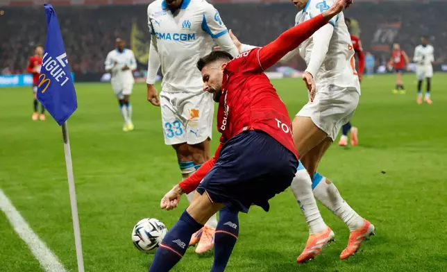 Lille's Olivier Giroud, centre, shoots the ball during the French League One soccer match between Lille and Marseille in Villeneuve-d'Ascq, outside Lille, France, Friday, Dec. 5, 2025. (AP Photo/Jean-Francois Badias)