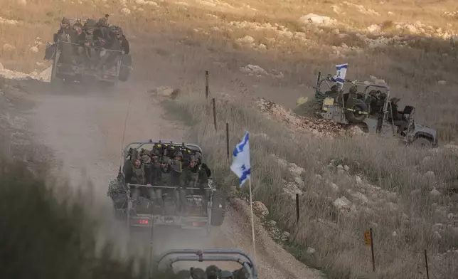 FILE - Israeli soldiers cross the security fence moving towards the so-called Alpha Line that separates the Israeli-annexed Golan Heights from Syria, in the town of Majdal Shams, Dec. 15, 2024. (AP Photo/Matias Delacroix, File)