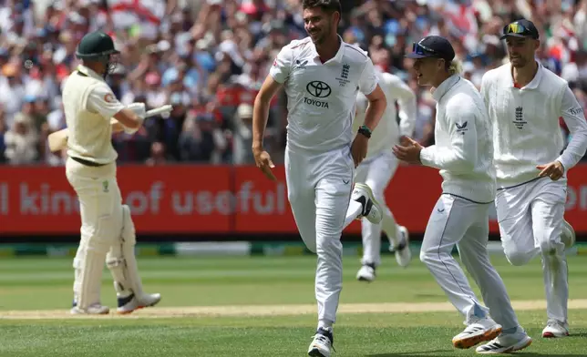 England's Josh Tongue, center, celebrates the wicket of Australia's Marnus Labuschagne, left, during their Ashes cricket test match in Melbourne, Friday, Dec. 26, 2025. (AP Photo/Hamish Blair)