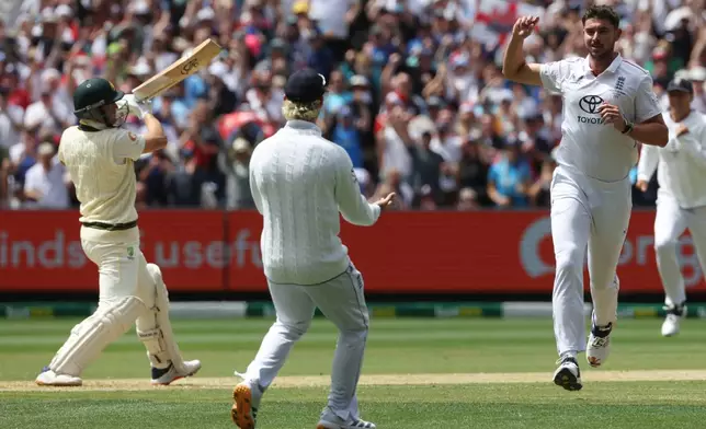 England's Josh Tongue, right, celebrates the wicket of Australia's Marnus Labuschagne, left, during their Ashes cricket test match in Melbourne, Friday, Dec. 26, 2025. (AP Photo/Hamish Blair)