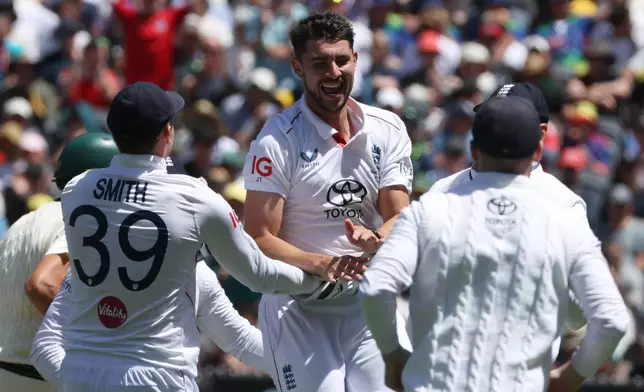 England's Josh Tongue, center, celebrates with teammates after taking the wicket of Australia's Scott Boland during their Ashes cricket test match in Melbourne, Friday, Dec. 26, 2025. (AP Photo/Hamish Blair)