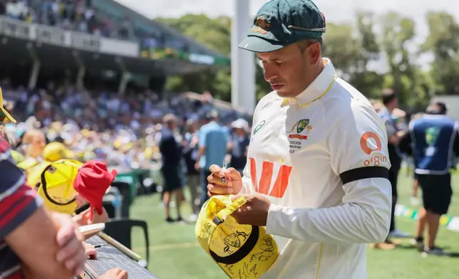 Australia's Usman Khawaja sign autograph to fans after they won the third Ashes cricket test match against England in Adelaide, Australia, Sunday, Dec. 21, 2025 (AP Photo/James Elsby)