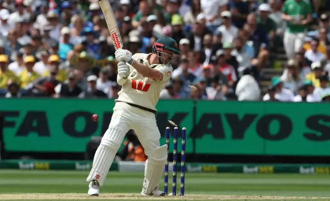 Australia's Travis Head is bowled by England's Gus Atkinson during their Ashes cricket test match in Melbourne, Friday, Dec. 26, 2025. (AP Photo/Hamish Blair)