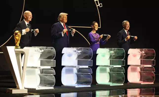 (left to right) FIFA President Gianni Infantino,President Donald Trump, Mexican President Claudia Sheinbaum and Canadian Prime Minister Mark Carney smile during the draw for the 2026 soccer World Cup at the Kennedy Center in Washington, Friday, Dec. 5, 2025. (Dan Mullan/Pool Photo via AP)