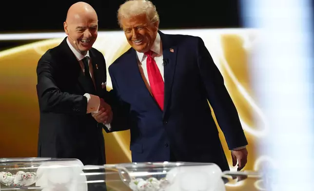 President Donald Trump is greeted by FIFA President Gianni Infantino during the draw for the 2026 soccer World Cup at the Kennedy Center in Washington, Friday, Dec. 5, 2025. (Jia Haocheng/Pool Photo via AP)