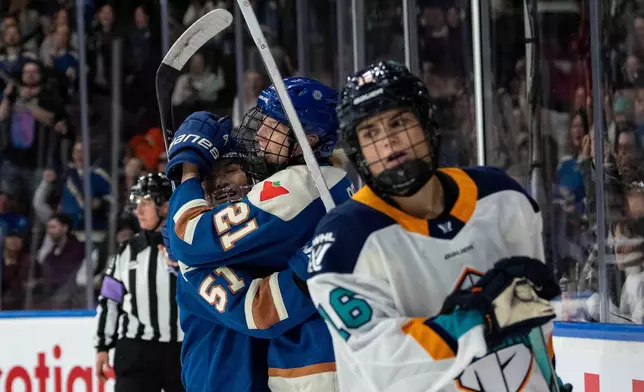Vancouver Goldeneyes' Ashton Bell (21) celebrates her goal with Anna Segedi (51) as New York Sirens' Lauren Bernard (16) skates away during the first period of a PWHL hockey game in Vancouver on Saturday, Dec. 6, 2025. (Ethan Cairns/The Canadian Press via AP)