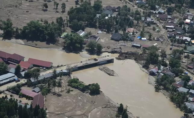 This aerial photo taken from a national disaster mitigation agency's helicopter during an aerial aid distribution shows an area affected by floods in Pidie Jaya, Aceh province, Indonesia, Thursday, Dec. 4, 2025. (AP Photo/Reza Saifullah)