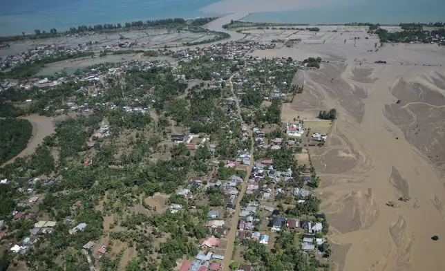 This aerial photo taken from a national disaster mitigation agency's helicopter during an aerial aid distribution shows an area affected by floods in Pidie Jaya, Aceh province, Indonesia, Thursday, Dec. 4, 2025. (AP Photo/Reza Saifullah)