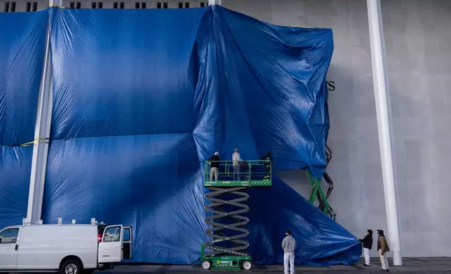 Tarps are installed in front of the sign at the Kennedy Center on Friday, Dec. 19, 2025, in Washington. (AP Photo/Mark Schiefelbein)