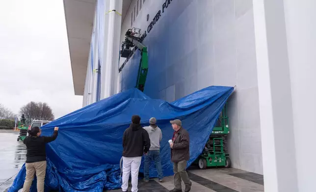 Tarps are installed in front of the sign on the Kennedy Center on Friday, Dec. 19, 2025, in Washington. (AP Photo/Mark Schiefelbein)