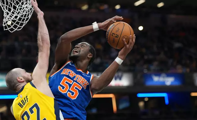 New York Knicks center Ariel Hukporti (55) shoots over Indiana Pacers center Jay Huff (32) during the first half of an NBA basketball game in Indianapolis, Thursday, Dec. 18, 2025. (AP Photo/AJ Mast)