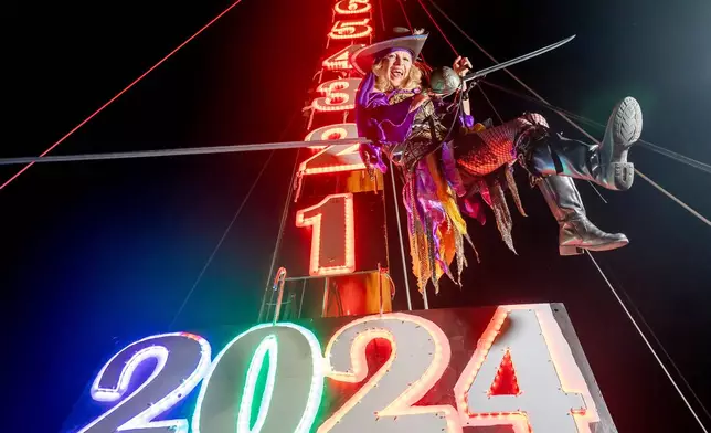 FILE - Evalena Worthington, owner of the Schooner Wharf Bar in Key West, practices the "Lowering of the Wench," from the 80-foot mast of the Schooner America 2, in Key West, Fla., Saturday, Dec. 30, 2023. . (Rob O'Neal/The Key West Citizen via AP, File)