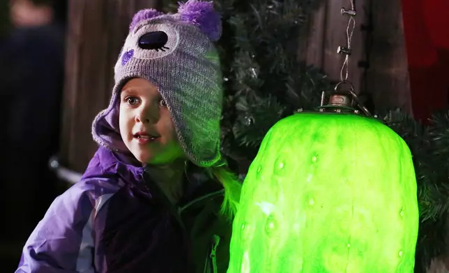 FILE - Sarah Searcy, 4, poses with the ceremonial pickle at the New Year's Eve Pickle Drop in Mount Olive, N.C., Wednesday night, Dec. 31, 2014. (Casey Mozingo/The Goldsboro News-Argus via AP, File)