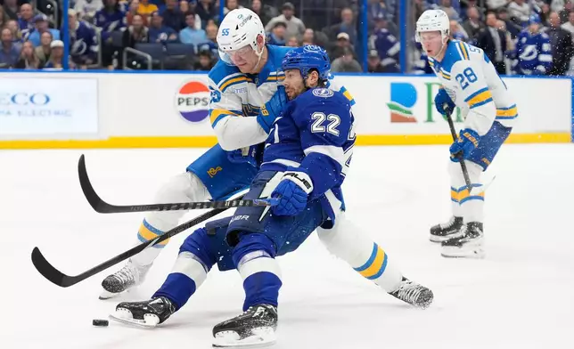 St. Louis Blues defenseman Colton Parayko (55) knocks Tampa Bay Lightning right wing Oliver Bjorkstrand (22) off the puck during the second period of an NHL hockey game Monday, Dec. 22, 2025, in Tampa, Fla. (AP Photo/Chris O'Meara)