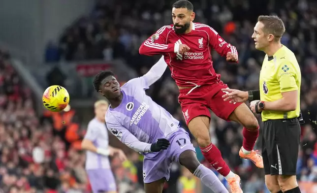 Liverpool's Mohamed Salah, centre, challenges for the ball with Brighton's Carlos Baleba, left, during the English Premier League soccer match between Liverpool and Brighton and Hove Albion in Liverpool, England, Saturday, Dec. 13, 2025. (AP Photo/Jon Super)