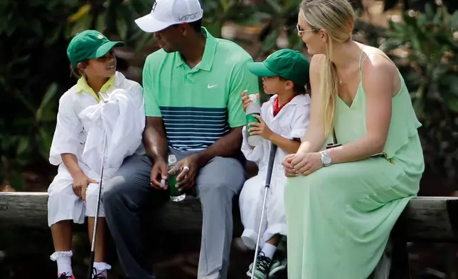FILE - Lindsey Vonn sits with Tiger Woods with his children Sam and Charlie during the Par 3 contest at the Masters golf tournament, April 8, 2015, in Augusta, Ga. (AP Photo/David J. Phillip, File)