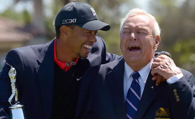 FILE - Tiger Woods, left, and Arnold Palmer share a laugh during the trophy presentation after Woods won the Arnold Palmer Invitational golf tournament, in Orlando, Fla., Monday, March 25, 2013. (AP Photo/Phelan M. Ebenhack, File)