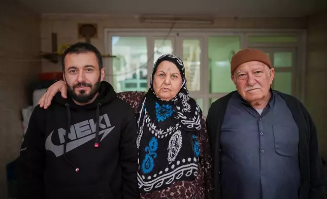 Syrian refugee Mohammed Dawood, 30, left, poses for a photo with his parents, Hayat Fatah, 65, center, and Abdulilah Amin Dawoud, 73, at their home in Irbil, Iraq, Nov. 16, 2025. (AP Photo/Farid Abdulwahed)