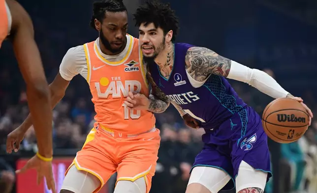 Charlotte Hornets guard Lamelo Ball, right, drives against Cleveland Cavaliers guard Darius Garland, left, in the first half of an NBA basketball game, Monday, Dec. 22, 2025, in Cleveland. (AP Photo/David Dermer)