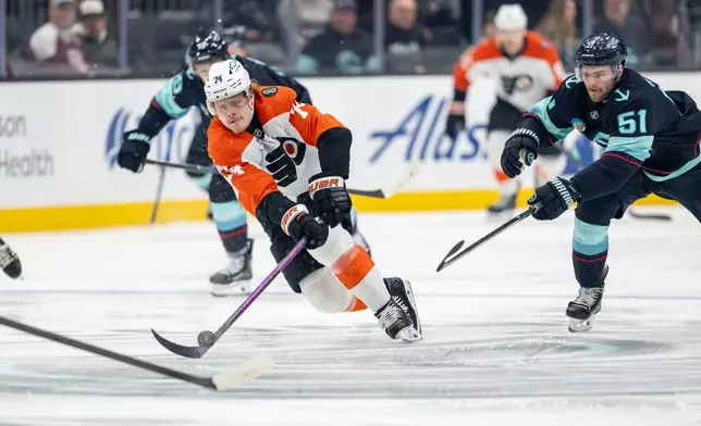Philadelphia Flyers forward Owen Tippett, left, skates against Seattle Kraken forward Shane Wright, right, during the second period of an NHL hockey game Sunday, Dec. 28, 2025, in Seattle. (AP Photo/Stephen Brashear)