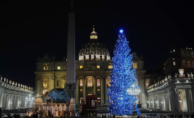 A 27-meter fir tree from the Ultimo valley in South Tyrol, Italy, is lit up as Christmas tree together with a crib in St. Peter's Square at the Vatican, Monday, Dec. 15, 2025. (AP Photo/Alessandra Tarantino)