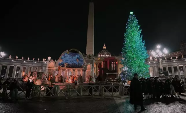 A 27-meter fir tree from the Ultimo valley in South Tyrol, Italy, is lit up as Christmas tree together with a crib in St. Peter's Square at the Vatican, Monday, Dec. 15, 2025. (AP Photo/Alessandra Tarantino)