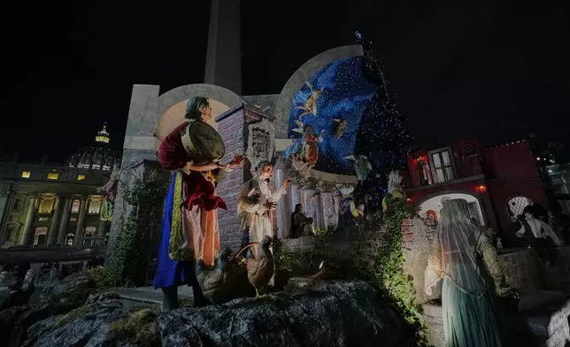 A nativity scene designed and crafted in Nocera Inferiore and Sarno in southern Italy, is lit up in St. Peter's Square at the Vatican, Monday, Dec.15, 2025. (AP Photo/Alessandra Tarantino)