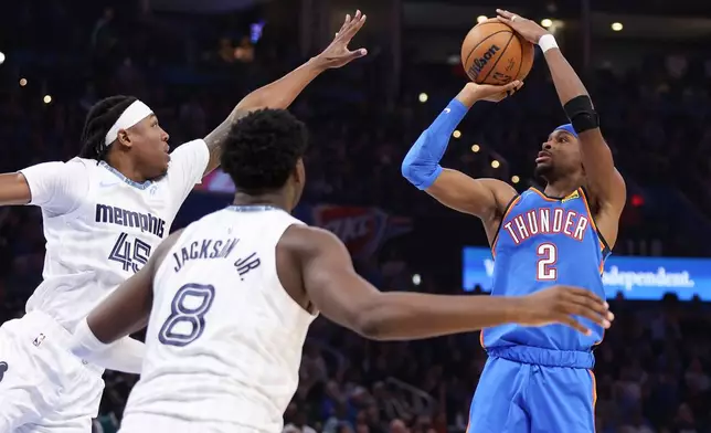 Oklahoma City Thunder guard Shai Gilgeous-Alexander (2) looks to shoot over Memphis Grizzlies forwards GG Jackson (45) and Jaren Jackson Jr. (8) during the second half of an NBA basketball game Monday, Dec. 22, 2025, in Oklahoma City. (AP Photo/Nate Billings)